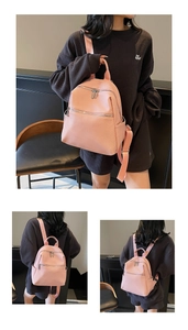Détail du sac à dos en cuir synthétique rose montrant la texture tissée et les fermetures éclair
