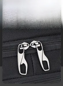 Close-up of smooth silver dual metal zippers on a durable black oxford commute backpack