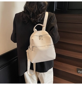 Détail d'un sac à dos en toile beige avec texture sergé et fermeture éclair argentée