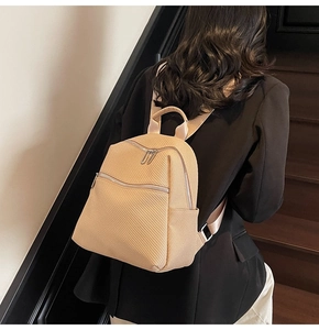 Détail d'un sac à dos beige en texture tressée avec double fermeture et bandoulières