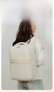 Woman wearing minimalist cream travel backpack with sleek matte faux leather texture