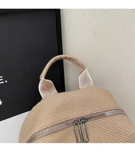 Close-up of durable top handle and metal dual zippers on beige water-resistant backpack