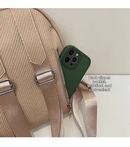 Detail of beige woven backpack featuring a rear anti-theft zipper pocket for smartphones