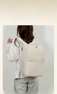 Rear view of a model wearing a cream travel backpack with wide comfortable shoulder straps