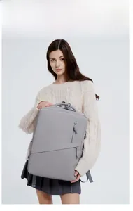 Gray laptop backpack detail showing waterproof fabric and diagonal zipper on a model
