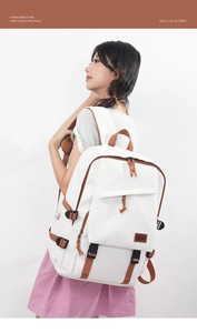 Asiatisches Model trägt großen weißen Nylonrucksack mit braunen Gurten und Lederdetails