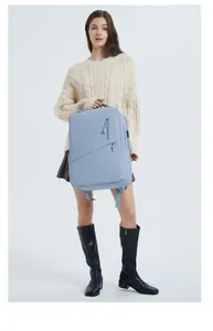 Detail of light blue laptop backpack with USB charging port and multiple zipper pockets