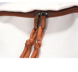 Makroaufnahme eines weißen Canvas-Rucksacks mit robustem braunem Doppelreißverschluss-Detail