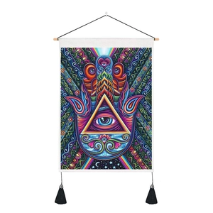 Détail de la tapisserie Main de Hamsa avec œil coloré, géométrie et pompons noirs