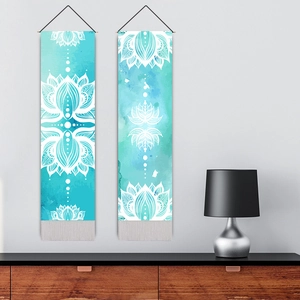Watercolour lotus mandala wall tapestries with tassels hanging above a wooden cabinet