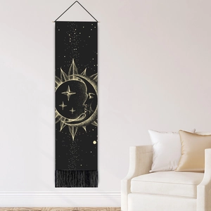 Tapisserie moderne noire avec motif céleste lune et soleil doré sur un mur blanc épuré