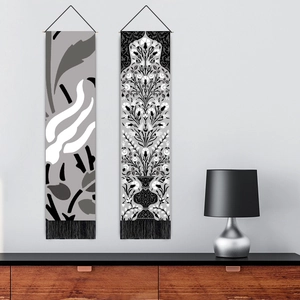 Close-up of minimalist black and white botanical canvas scrolls with fringe details