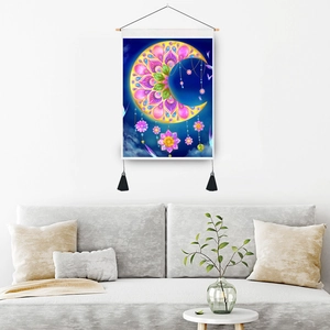 Bohemian moon tapestry with floral patterns and wooden hanger above a modern sofa