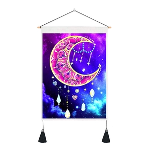 Detail of moon and stars tapestry with gold mandala moon, tassels and wooden hanging pole