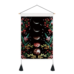 Detail of moon phase wall tapestry with botanical floral patterns and wooden hanger