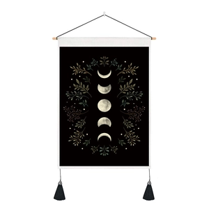 Detail of bohemian moon phase tapestry with black fabric and wooden hanging rod