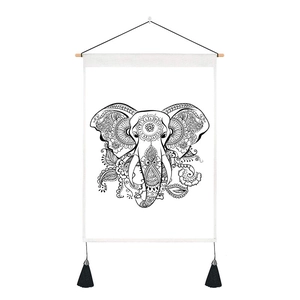Detail of bohemian elephant wall hanging with wooden rod, black tassels and mandala patterns