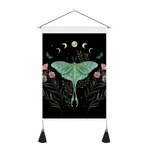 Close-up of Luna Moth tapestry with floral moon phases and hanging wooden poles