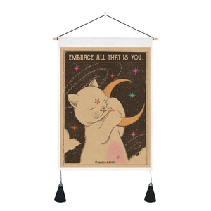 Detail of vintage cat and moon tapestry with black tassels and wooden hanging rod