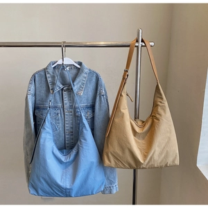 Detail of large nylon hobo bags in blue and khaki hanging to show drape and texture