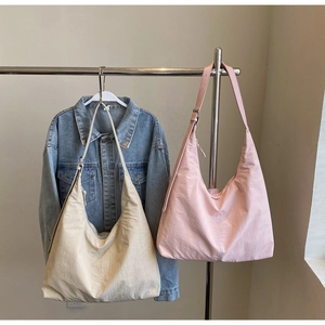 Detail of beige and pink oversized hobo tote bags with adjustable wide shoulder straps