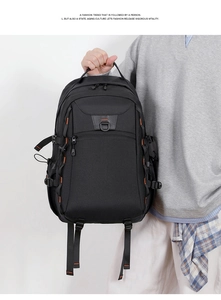 Detail of black nylon backpack with orange stitching and D-ring buckle