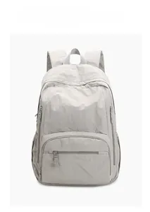 Detail view of the lightweight grey nylon backpack showing zippers and side pocket storage