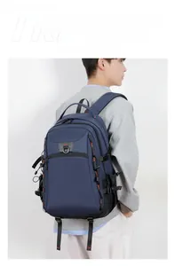 Side view of dark blue multi-compartment travel backpack with orange stitching details