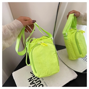Detail of neon green crossbody sports bag with drawstring closure and front zipper pocket