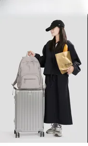 Grey nylon backpack on silver suitcase showing its large capacity and water-resistant fabric