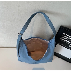 Detail view of large capacity hobo bag interior with zip closure and adjustable strap