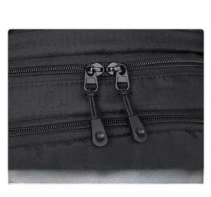 Close-up of durable dual zippers with nylon pulls on a black outdoor backpack