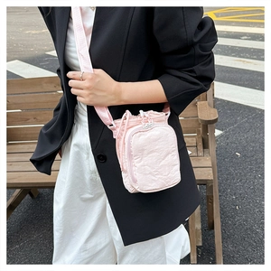 Detail of light pink multifunctional crossbody bag with adjustable strap and zip pocket