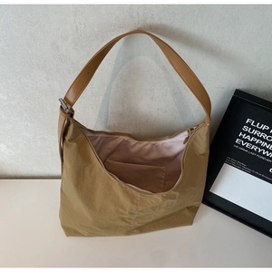 Detail view of khaki tote bag showing interior lining and adjustable wide shoulder strap