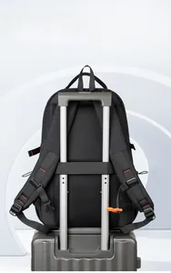 Detail view of black travel backpack with breathable mesh back and luggage strap on suitcase