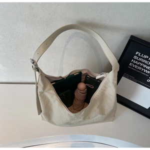 Spacious interior of a beige tote bag holding a tablet, phone, and folded umbrella