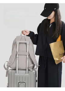 Detail view of lightweight gray backpack showing convenient luggage strap on the back