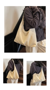 Detail of oatmeal tote bag with adjustable wide strap shown on model in urban setting
