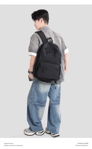 Rear view of a model wearing a black nylon backpack for daily commute and hiking