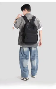 Detail view of lightweight black nylon backpack with multi-compartment storage zippers
