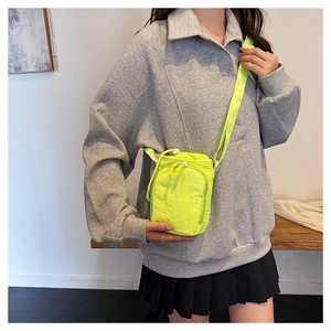 Neon green crossbody sports bag with drawstring closure and adjustable strap on model
