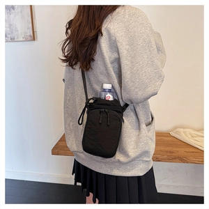 Detail showing back view of black nylon crossbody water bottle bag for outdoor sports