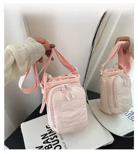 Detail view of pink nylon bucket bag with drawstring closure and front zipper pocket