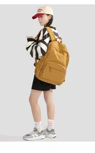 Detail view of mustard yellow lightweight nylon backpack with padded shoulder straps
