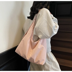 Macro detail of large pink nylon tote bag showing soft texture and crossbody strap