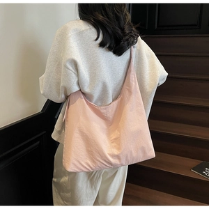 Detailed back view of a pink minimalist large capacity hobo bag on a shoulder