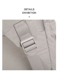 Detailed close-up of adjustable strap buckle and reinforced stitching on nylon backpack