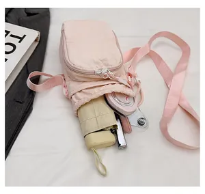 Pink crossbody phone bag interior view showing storage for phone, lipstick, and umbrella