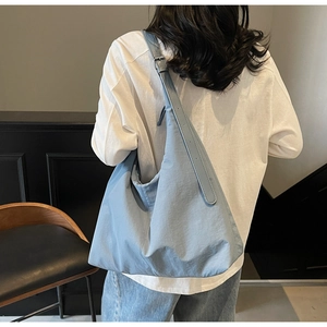 Close-up of light blue large capacity tote bag featuring adjustable shoulder strap and soft texture