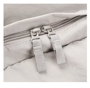Detailed macro view of durable SBS brand two-way zippers on lightweight nylon backpack
